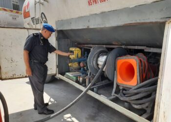 PEGAWAI KPDNHEP Perak memeriksa lori tangki yang dirampas dalam serbuan di sebuah premis di Kawasan Perindustrian Silibin, Ipoh semalam. - UTUSAN