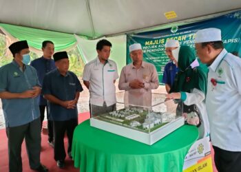 IDRIS Ahmad (tengah) mendengar penerangan mengenai pelan pembinaan Kompleks Pendidikan Yayasan Pendidikan Islam Selangor dalam majlis pecah tanah projek tersebut di Sungai Panjang di Sabak Bernam, Selangor.