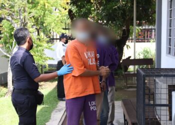 SUSPEK (depan) kes bunuh dan kerat mayat ibu pada Ahad lalu di bawa ke Mahkamah Majistret Parit Buntar hari ini untuk prosiding reman.  - UTUSAN/MUHAMAD NAZREEN SYAH MUSTHAFA