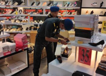 ANGGOTA penguat kuasa KPDNHEP Perak menjalankan pemeriksaan di sebuah kedai yang disyaki menjual kasut tiruan jenama terkenal di Jalan Sultan Abdul Jalil, Ipoh. - UTUSAN/IHSAN KPDNHEP