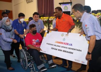 M. SARAVANAN (dua dari kanan) menyampaikan cek hilang upaya sementara dan kerusi roda kepada Ishak Ibrahim pada Karnival Kerjaya Jamin Kerja Keluarga Malaysia 2022 Negeri Perak di Tapah hari ini. - UTUSAN/MUHAMAD NAZREEN SYAH MUSTHAFA