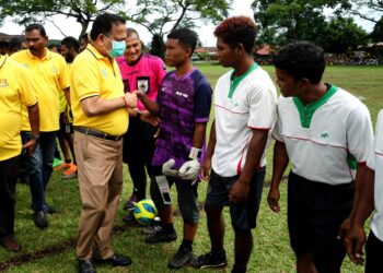 S.A Vigneswaran (kiri) beramah mesra bersama pemain yang menyertai pertandingan bola sepak 9 sepasukan tertutup Parlimen Sungai Siput di Sungai Siput hari ini. - UTUSAN/ZULFACHRI ZULKIFLI