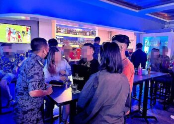 PEGAWAI Imigresen memeriksa dokumen pelanggan di sebuah pusat hiburan di Sandakan baru-baru ini. - IHSAN IMIGRESEN