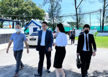 CHONG Zhemin (dua kiri)  selepas membuat laporan polis di Jabatan Siasatan Jenayah Komersial Balai Polis Sungai Senam di Ipoh hari ini. - UTUSAN