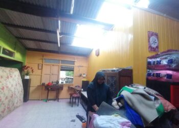 NORAFIZAH Mohd. Nor mengemas rumahnya selepas kejadian ribut di Kampung Bukit Kolam, Ajil, Hulu Terengganu, hari ini. - UTUSAN/NOOR HAYATI MAMAT