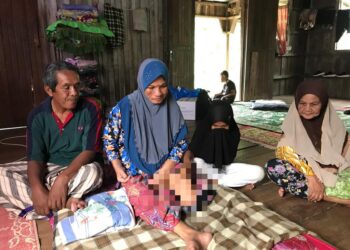 MOHD. Rafiee Jenal (kiri) melihat kaki isterinya Mohayati Che Pa (dua dari kiri) yang terpaksa dipotong akibat kencing manis di rumahnya di Kampung Limau Kasturi 1, Gua Musang, Kelantan. - AIMUNI TUAN LAH
