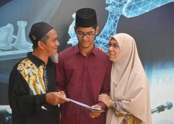 TENGKU Abdul Aziz Md. Fauzi (tengah) menerima ucapan tahniah daripada bapa, Tengku Md. Fauzi Tengku Mahmud dan ibu, Wan Hindon Wan Abdullah selepas menerima Anugerah Pelajar Cemerlang SPM 2021 di Kuala Terengganu, hari ini. - UTUSAN/PUQTRA HAIRRY ROSLI