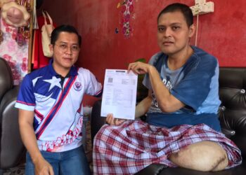 MOHAMAD Azizan menunjukkan bil dari pada sebuah hospital di Singapura berjumlah $89,000 yang dihantar menerusi pos ke Mahkamah Muar beberapa bulan lalu kepada Pengerusi Kelab Kebajikan Anak Jati Muar (KKAJM), Tarmizi Yahya.