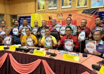 MD. Fiah Md Jamin (duduk tengah) menunjukkan laporan keputusan SPM Negeri Sembilan dalam sidang akhbar di Seremban hari ini. - UTUSAN/ZAKKINA WATI AHMAD TARMIZI