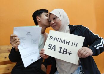 MUHAMMAD Shamil Aiman Norsham (kiri) mencium pipi Siti Khajura Badros selepas diumumkan memperoleh 9A dan 1B dalam SPM 2021 ketika ditemui di SMK Bukit Rambai, Melaka. - UTUSAN/MUHAMMAD SHAHIZAM TAZALI