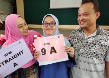 NURIN Faqihah Fazli (tengah) ditemani ibu bapanya selepas mendapat keputusan cemerlang semua A dalam SPM 2021 ketika ditemui pemberita di Dewan SMK Tunku Besar Tampin, Tampin, hari ini.-UTUSAN/NOR AINNA HAMZAH