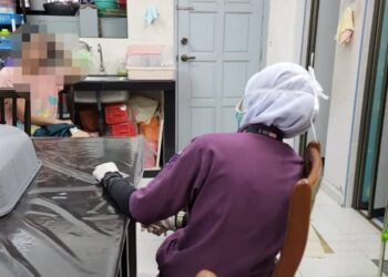 MANGSA (kiri) ditenangkan oleh anggota bertugas selepas berjaya dipujuk dalam kejadian di Jalan Hang Tuah, Banda Hilir, Melaka.