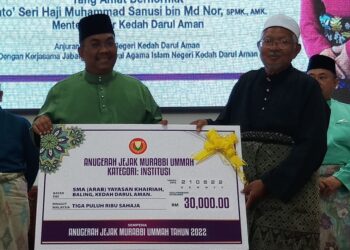 MUHAMMAD Sanusi Md. Nor (kiri) menyampaikan Anugerah Jejak Murabbi Ummah Kategori Institusi kepada Pengetua Sekolah Menengah Agama Yayasan Khairiah, Ustaz Abdul Rahman Yahya Taha di Kampung Pisang, Kupang, hari ini. - UTUSAN/NORLIA RAMLI