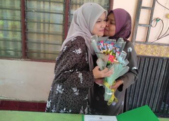 AIN NATASHA Anizul (kiri) menerima ciuman daripada ibunya, Mazarina Mat Zain selepas menerima keputusan peperiksaan Sijil Pelajaran Malaysia 2021 di Felda Kota Gelanggi Dua, Jerantut, Pahang. - UTUSAN/HARIS FADILAH AHMAD