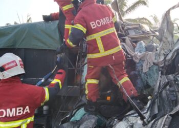 ANGGOTA bomba mengeluarkan pemandu lori yang tersepit dalam kemalangan di Jalan Sitiawan - Teluk Intan semalam. - UTUSAN/IHSAN JBPM