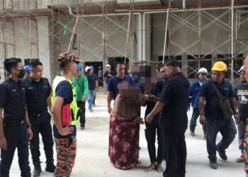 Anggota keselamatan menenangkan lelaki yang cuba terjun dari kren di tapak pembinaan di Lembah Sireh, Kota Bharu, Kelantan, kelmarin. - IHSAN JBPM KELANTAN
