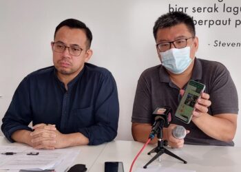 TAN Ban Kheng (kanan) menunjukkan rakaman suara dipercayai daripada wakil sebuah parti politik yang mengugut dan memintanya menarik balik laporan polis yang dibuat berhubung sindiket penipuan kerja di Georgetown dan Kemboja sebelum ini.