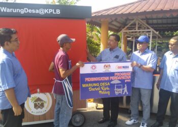 ABDUL RAHMAN Mohamad (tiga dari kanan) menyampaikan peralatan gerai jualan di bawah bantuan WarungDesa@KPLB Program Peningkatan Pendapatan kepada peniaga roti canai, Oslan Awang Othman di Jalan Batu Dua, Kuala Lipis di Lipis, Pahang. - UTUSAN/HARIS FADILAH AHMAD