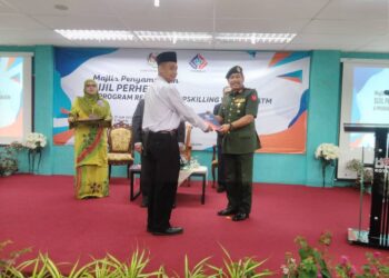 ABU Hassan Assha'ari Khamis 
(kanan) menyampaikan sijil kepada salah seorang peserta kursus kendalian Perhebat di Kolej Poly Tech Mara, Kota Bharu, Kelantan hari ini.-UTUSAN/ ROHANA MOHD.NAWI.