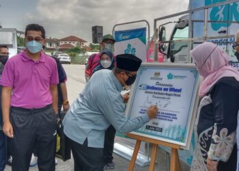 MOHD. Akmal Kamaruddin menandatangani plak perasmian pameran bergerak Wellness On Wheel pada sambutan Hari Denggi Asean Peringkat Negeri Perak 2022 di Sitiawan, hari ini. - UTUSAN/SHAMSUL KAMAL AMARUDIN