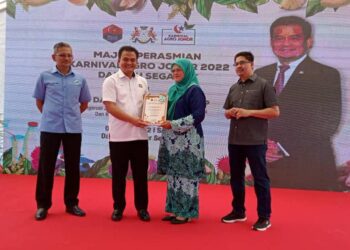 ZAHARI Sarip (dua kiri baju putih) menyampaikan Sijil Anugerah Peneraju Inovasi Agro Makanan 2022 kepada seorang usahawan pertanian di Program Karnival Agro Johor 2022 di Dataran Segamat
