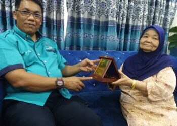 BAHARUDIN Abu (kiri) dan Zainab menunjukkan plak penghargaan dan kad bekas anggota polis itu ketika menziarahnya dekat rumah di Meru, Klang, Selangor, hari ini.