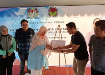 ZURAIDA Kamaruddin (tengah) mencuba produk coklat yang dihasilkan oleh TAE ketika lawatannya ke ladang koko syarikat itu di Kampung Panchor, Alor Gajah, Melaka. - UTUSAN/HADI AB. MANAP