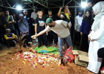 Adam Abdullah menabur bunga di pusara cucunyq Hans Mohd. Thakif Amir dan menantunya, Hajar Nur Syahirin Rosman di Tanah perkuburan Islam Kampung Bakar Batu, Johor Bahru