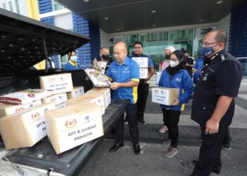 ZALIMAN SAULI (tiga dari kiri) memeriksa barang makanan pada pelepasan misi bantuan pada Majlis Pelepasan Op Kasih Banjir Baling, Kedah di Unimap di sini semalam.