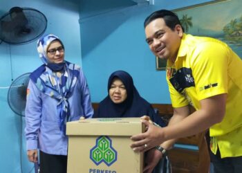 AHMAD Saidi Mohamad Daud (kanan) menyampaikan bantuan alatan pemulihan kepada orang berinsurans, Hasliza Abdul Karim (tengah) di Persiaran Klebang Selatan, Ipoh hari ini. - UTUSAN