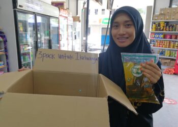 NURAIN Syahirah Rozali menunjukkan minyak masak peket yang terhad di kedainya di Kemaman, Terengganu, hari ini. - UTUSAN/NIK NUR IZZATUL HAZWANI NIK ADNAN