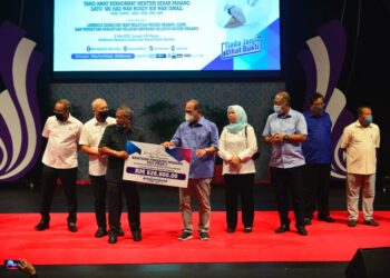 WAN ROSDY Wan Ismail (empat, kiri) menyampaikan bantuan BPP kategori nelayan keseluruhannya bernilai RM626,600 di Auditorium Penyiaran Sultan Haji Ahmad Shah di Kuantan, Pahang. - UTUSAN/SHAIKH AHMAD RAZIF