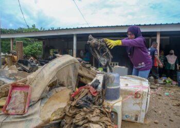 PENDUDUK bersama sukarelawan bergotong-royong membersihkan rumah dan barang-barang yang rosak dalam kejadian banjir dan kepala air di Kampung Iboi, Kupang. -UTUSAN/ SHAHIR NOORDIN