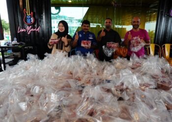 MOHAMED Ali MK Osman (kanan) bersama-sama para petugasnya menunjukkan bungkusan daging kambing korban yang diagih-agihkan kepada golongan asnaf dan anak yatim sempena Aidiladha pada majlis Korban Perdana The J Seri Alam, Bandar Seri Alam, Masai di sini.