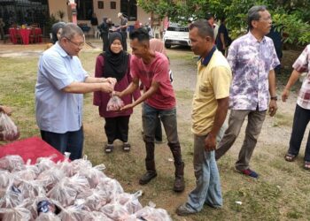 SAIFUDDIN Abdullah (dua dari kiri) turut serta dalam program penyembelihan dan pengagihan daging korban yang diadakan di Sungai Karang di Kuantan, Pahang. - UTUSAN/DIANA SURYA ABD WAHAB