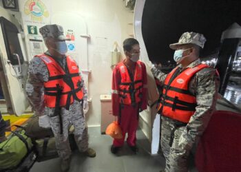 DUA anggota Maritim Malaysia bertanyakan sesuatu kepada warga Vietnam yang diselamatkan oleh petugas Pelantar Lawit A di perairan Terengganu, Ahad lalu.