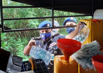 A. MOGAN (tengah) ketika melakukan serbuan ke atas sebuah lori yang membawa minyak masak bersubsidi dan diseleweng sebelum dipek semula serta diedarkan ke pasaran sebagai minyak sembahyang di Butterworth, Pulau Pinang hari ini.