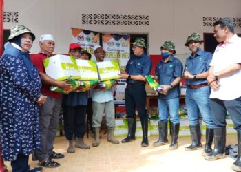 MOHD. Salim Mohd. Sharif (empat dari kanan) menyampaikan bantuan kepada pekebun kecil yang terjejas banjir di Kampung Iboi, Kupang di Baling. -UTUSAN/NORLIA RAMLI