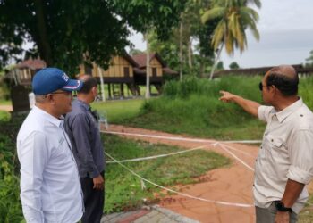 AB. Wahab Azizul Hassan (kanan) meninjau keadaan Rumah Datuk Maharajalela dari laluan masuk ke rumah itu ketika melawat beberapa ikon bersejarah di Pasir Salak hari ini. - UTUSAN/AIN SAFRE BIDIN
