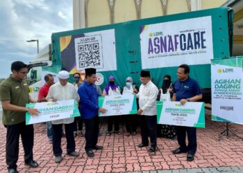 SYEIKH Zakaria Othman (tiga dari kanan) menyampaikan sumbangan kepada penerima pada program Perasmian Agihan Daging Korban Kepada Asnaf Kedah di Kolej Agama Sultan Abdul Halim, hari ini. -UTUSAN/JAMLIAH ABDULLAH