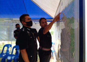 YUSHARIFUDDIN Mohd. Yusop (kiri) mendengar taklimat daripada pegawai bertugas sewaktu turun padang ke Pusat Operasi SAR bagi mencari seorang lelaki hilang sejak lima hari lalu di Jalan Bukit Ayer, Kangar, Perlis hari ini. - UTUSAN/ASYRAF MUHAMMAD