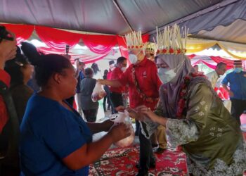 TENGKU Tan Sri Mohamad Rizam Tengku Abdul Aziz (kiri) bersama isterinya, Puan Sri Tunku Noor Hayati Tunku Abdul Rahman Putra Al-Haj  menyampaikan daging korban kepada penduduk Orang Asli di Rancangan Pengumpulan Semula (RPS) Kuala Betis, Gua Musang, Kelantan, hari ini.-UTUSAN/AIMUNI TUAN LAH