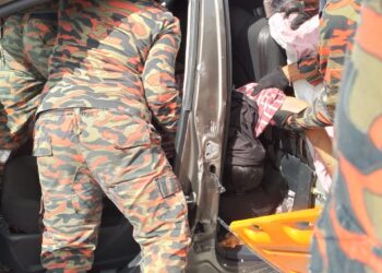 ANGGOTA bomba mengeluarkan mangsa yang tersepit dalam kemalangan tujuh kenderaan di Kilometer 277.1, Lebuh Raya Utara-Selatan arah selatan dekat Ipoh hari ini. - UTUSAN/JBPM PERAK