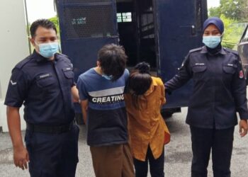 SUSPEK diiringi oleh polis semasa menghadiri perbicaraan di Mahkamah Majistret, Kota Bharu, Kelantan hari ini.