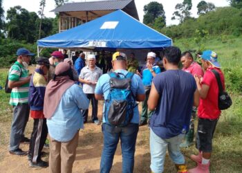 ABDUL Halim Ismail (empat dari kiri) berdoa mengiringi operasi pencarian anaknya oleh pasukan keselamatan dan penduduk kampung di kawasan bukit berhampiran Sungai Batu Pahat, Jalan Bukit Ayer, Kangar, Perlis hari ini. - UTUSAN/ASYRAF MUHAMMAD