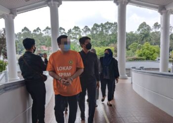KEDUA-DUA suspek diiring keluar anggota SPRM selepas perintah reman dikeluarkan Mahkamah Majistret, Ayer Keroh, Melaka. - UTUSAN/MUHAMMAD SHAHIZAM TAZALI