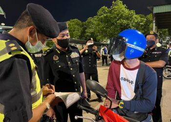 ADENAN Md. Isa  memeriksa penunggang motosikal dalam Op Khas Motosikal (HRAA) 2022 di susur masuk Jambatan Pulau Pinang malam tadi. - UTUSAN/SITI NUR MAS ERAH AMRAN
