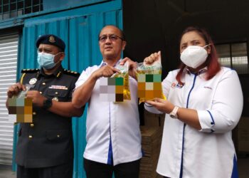 NORENA Jaafar (kanan) menunjukkan minyak masak peket satu kg yang memiliki logo subsidi ketika membuat pemeriksaan mengejut di kilang pembungkusan sekitar Batu Berendam, Melaka. - UTUSAN/MUHAMMAD SHAHIZAM TAZALI