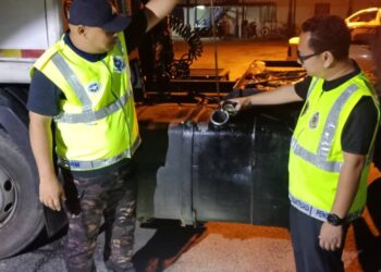 ANGGOTA Penguatkuasa KPDNHEP Kelantan (kanan) bersama polis memeriksa lori yang digunakan untuk menyelup selepas ditahan dalam serbuan di ladang kelapa sawit Kampung  Rahmat Lubuk Setol, Rantau Panjang, Kelantan hari ini. -UTUSAN/KPDNHEP KELANTAN