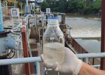 ANGGOTA LUAS menunjukkan sampel air yang diambil dekat muka sauk LRA di Batu 11, Cheras selepas pihaknya menerima aduan mengenai kewujudan kesan minyak pada Sungai Langat, Selangor, semalam.